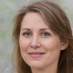 Joyful white adult female with long  brown hair and brown eyes