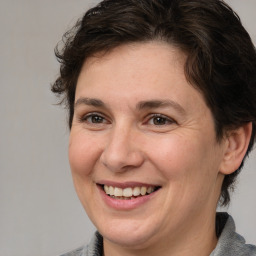 Joyful white adult female with medium  brown hair and brown eyes