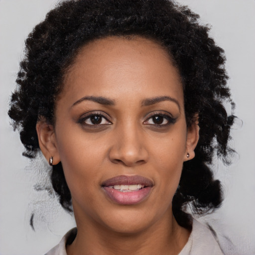 Joyful black young-adult female with medium  black hair and brown eyes