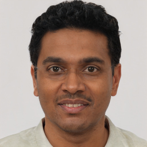 Joyful black young-adult male with short  black hair and brown eyes