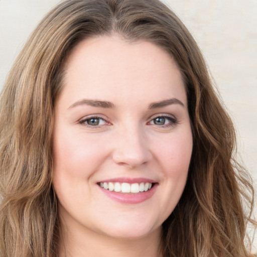 Joyful white young-adult female with long  brown hair and green eyes