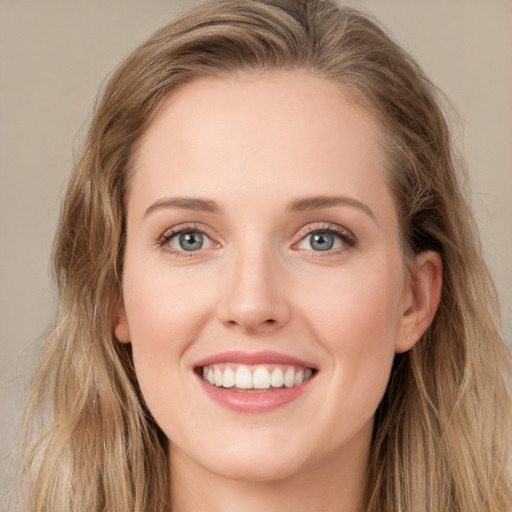 Joyful white young-adult female with long  brown hair and green eyes