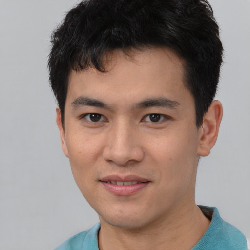 Joyful asian young-adult male with short  black hair and brown eyes