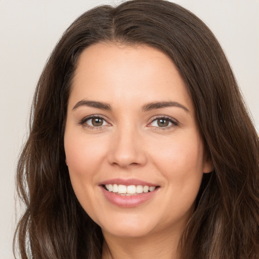 Joyful white young-adult female with long  brown hair and brown eyes