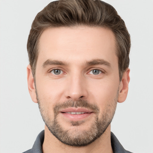 Joyful white young-adult male with short  brown hair and grey eyes