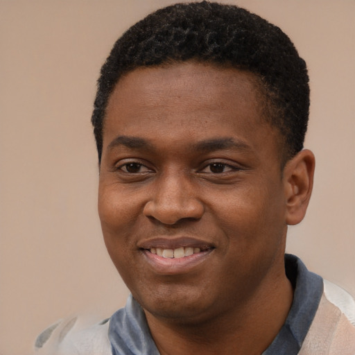 Joyful black young-adult male with short  black hair and brown eyes