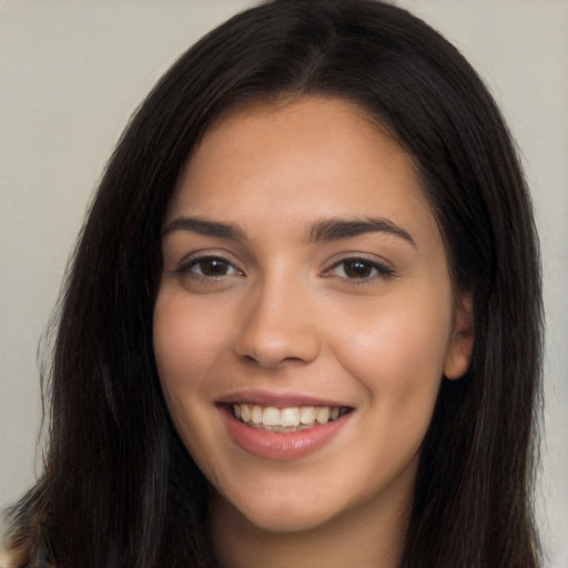 Joyful latino young-adult female with long  brown hair and brown eyes