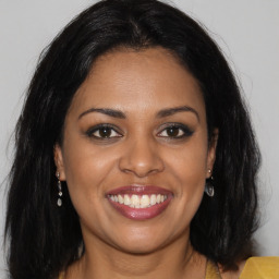 Joyful black young-adult female with long  brown hair and brown eyes