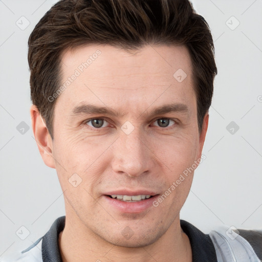 Joyful white young-adult male with short  brown hair and grey eyes