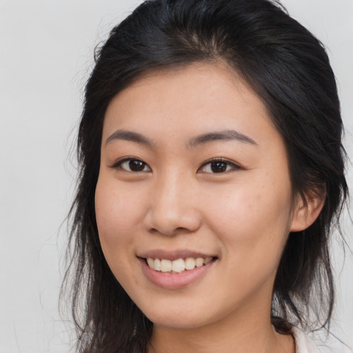 Joyful asian young-adult female with long  brown hair and brown eyes