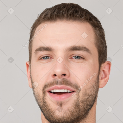 Joyful white young-adult male with short  brown hair and grey eyes