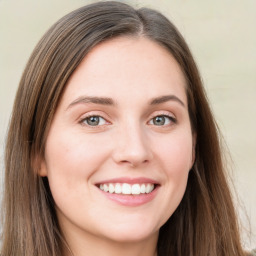 Joyful white young-adult female with long  brown hair and green eyes