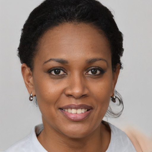 Joyful black young-adult female with short  brown hair and brown eyes