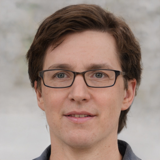 Joyful white adult male with short  brown hair and grey eyes