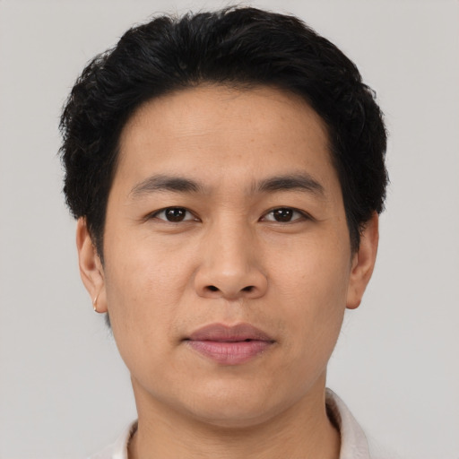 Joyful asian young-adult male with short  brown hair and brown eyes