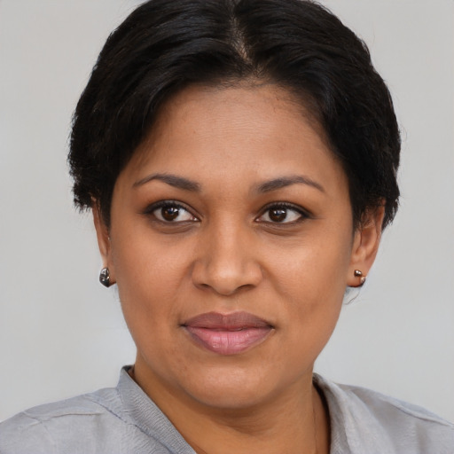 Joyful black young-adult female with short  brown hair and brown eyes