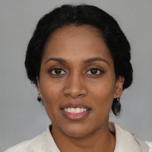 Joyful black adult female with short  black hair and brown eyes