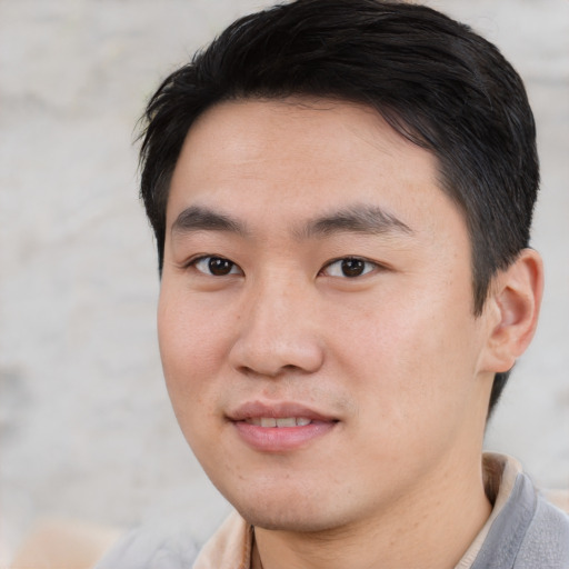 Joyful asian young-adult male with short  black hair and brown eyes