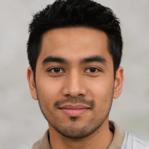 Joyful latino young-adult male with short  black hair and brown eyes