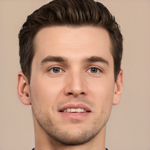 Joyful white young-adult male with short  brown hair and grey eyes