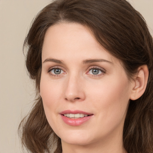 Joyful white young-adult female with medium  brown hair and green eyes