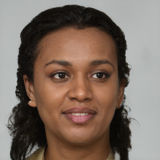 Joyful black young-adult female with long  brown hair and brown eyes