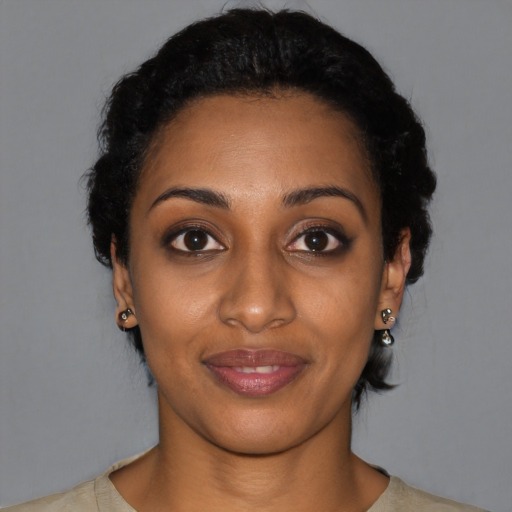 Joyful black young-adult female with short  black hair and brown eyes