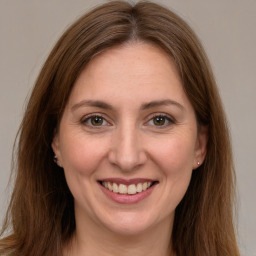 Joyful white adult female with long  brown hair and brown eyes