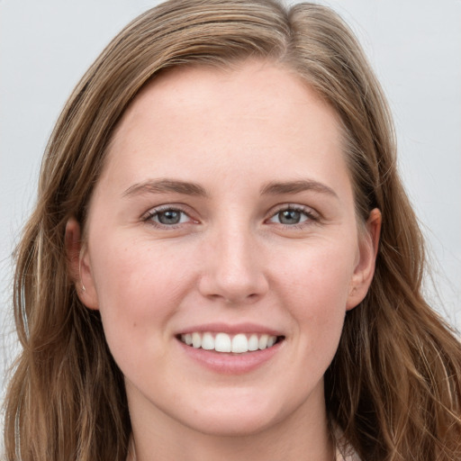 Joyful white young-adult female with long  brown hair and blue eyes