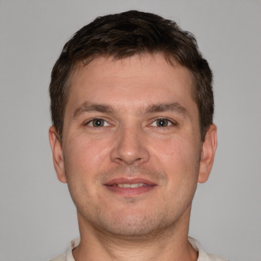 Joyful white young-adult male with short  brown hair and brown eyes