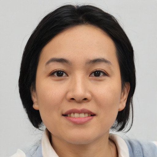 Joyful asian young-adult female with medium  black hair and brown eyes