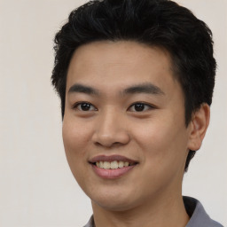 Joyful asian young-adult male with short  black hair and brown eyes