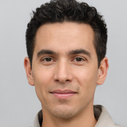 Joyful white young-adult male with short  black hair and brown eyes