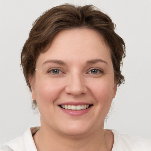 Joyful white young-adult female with short  brown hair and grey eyes