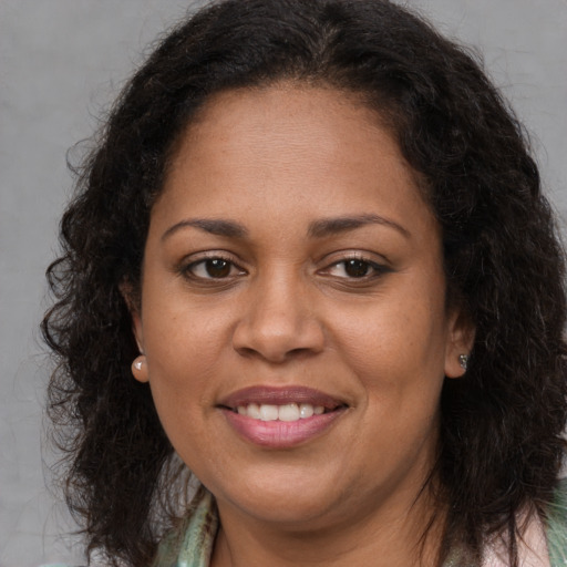 Joyful black adult female with long  brown hair and brown eyes