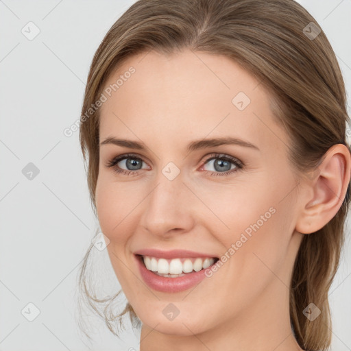 Joyful white young-adult female with long  brown hair and blue eyes