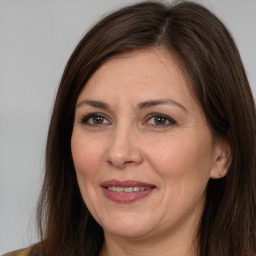 Joyful white adult female with long  brown hair and brown eyes