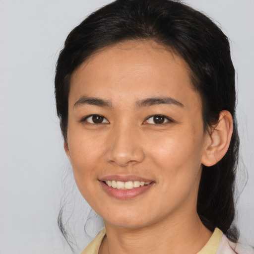 Joyful asian young-adult female with medium  brown hair and brown eyes