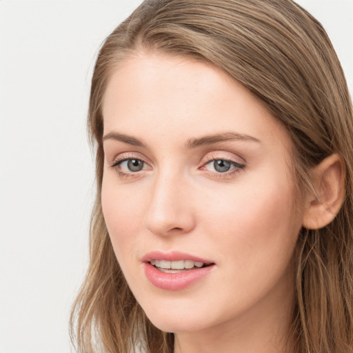 Joyful white young-adult female with long  brown hair and blue eyes