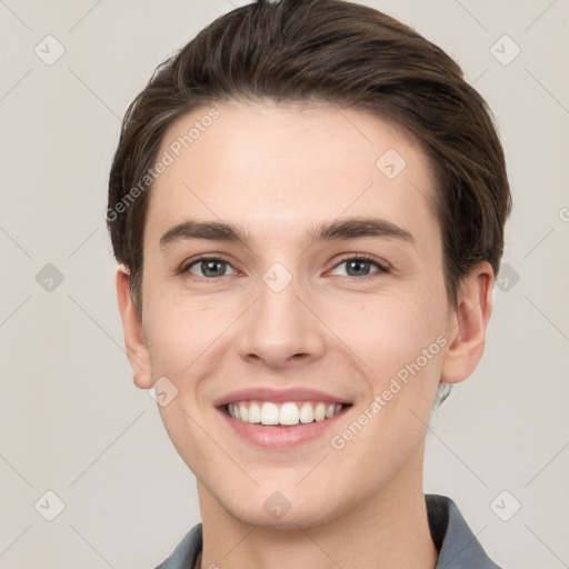 Joyful white young-adult male with short  brown hair and grey eyes