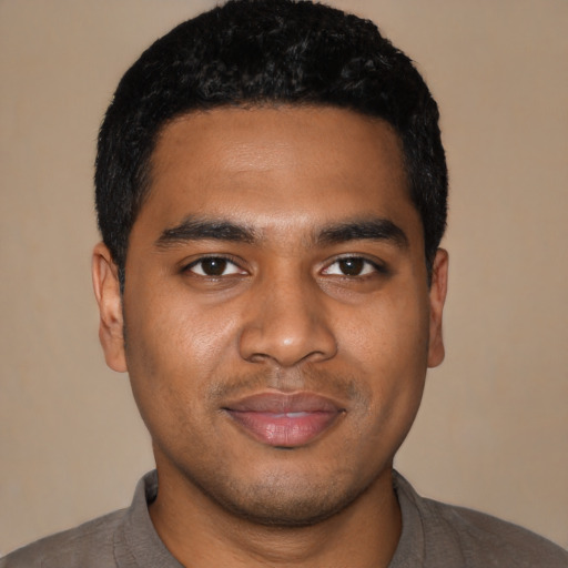 Joyful black young-adult male with short  black hair and brown eyes