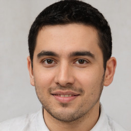 Joyful white young-adult male with short  black hair and brown eyes