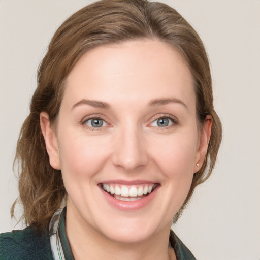 Joyful white young-adult female with medium  brown hair and blue eyes