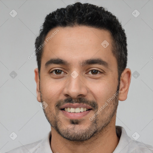 Joyful white young-adult male with short  black hair and brown eyes