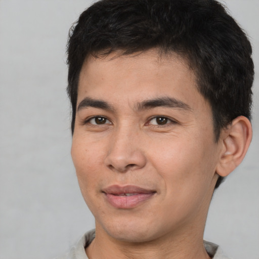 Joyful asian young-adult male with short  brown hair and brown eyes