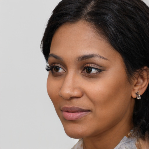 Joyful latino young-adult female with short  black hair and brown eyes