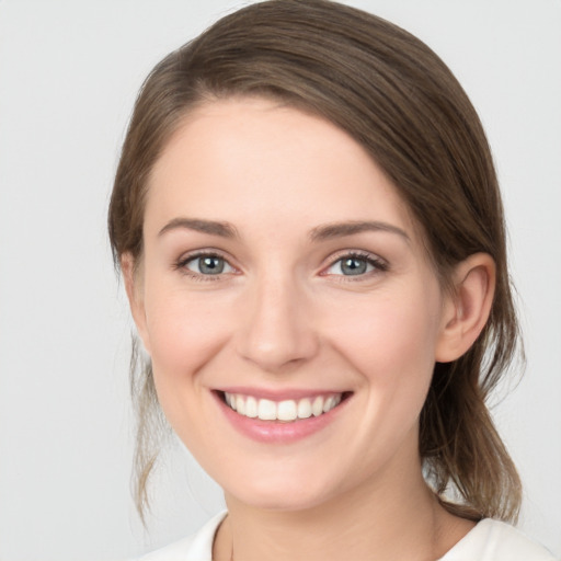 Joyful white young-adult female with medium  brown hair and green eyes