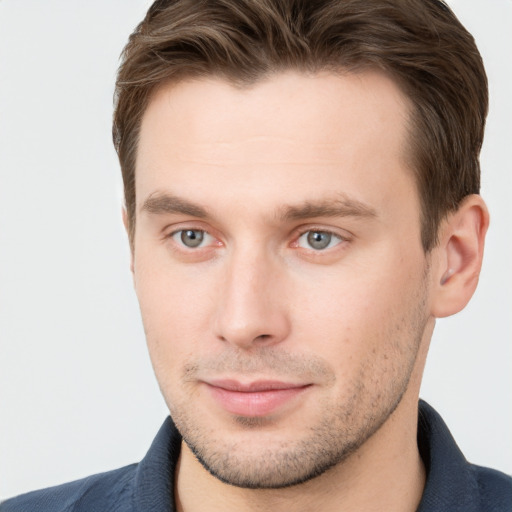 Joyful white young-adult male with short  brown hair and grey eyes