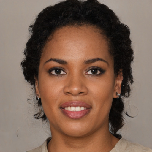 Joyful black young-adult female with medium  black hair and brown eyes