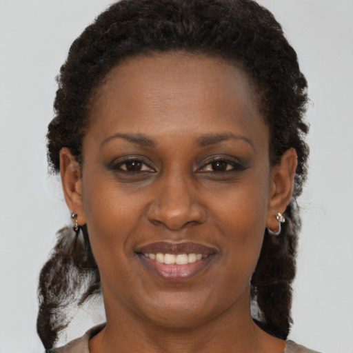 Joyful black adult female with medium  brown hair and brown eyes